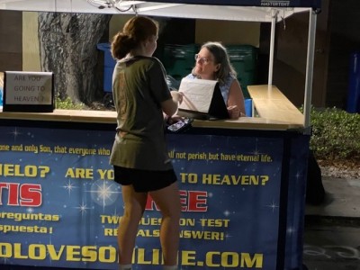 A woman interacting with another woman at a fair booth